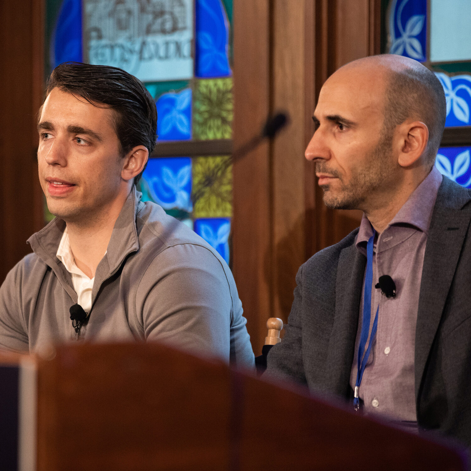 A Demo Day panelist speaking from a seated position, as other panelists react.