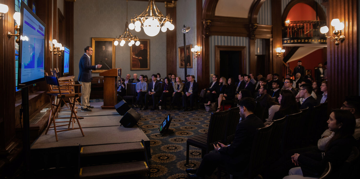 A speaker gives a keynote address in front of a full audience at Demo Day