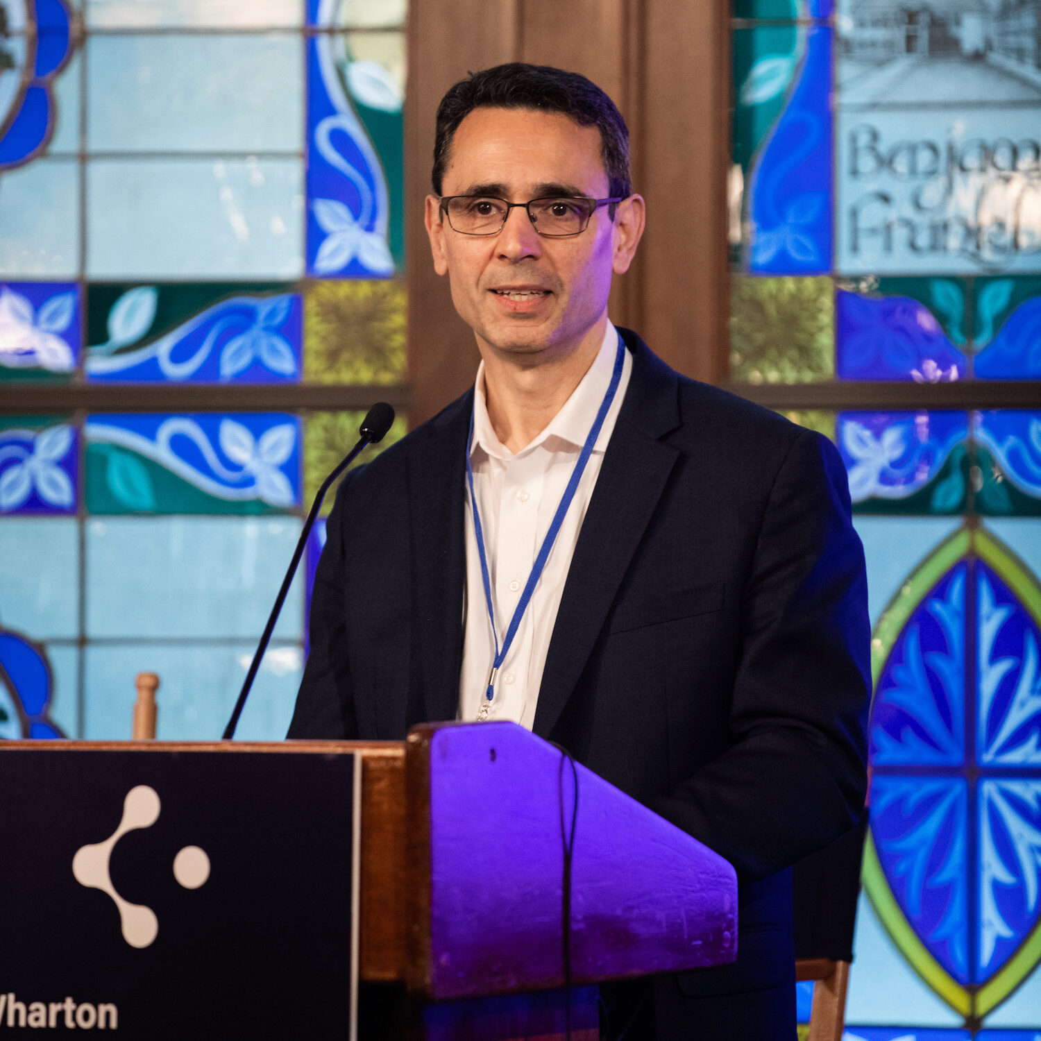 A person with glasses speaks at a podium with the Cypher Accelerator logo